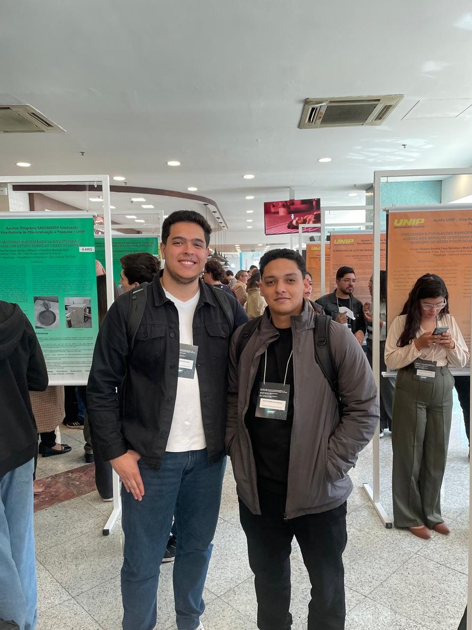 Dois estudantes do curso em sessão de pôsteres de congresso de iniciação científica