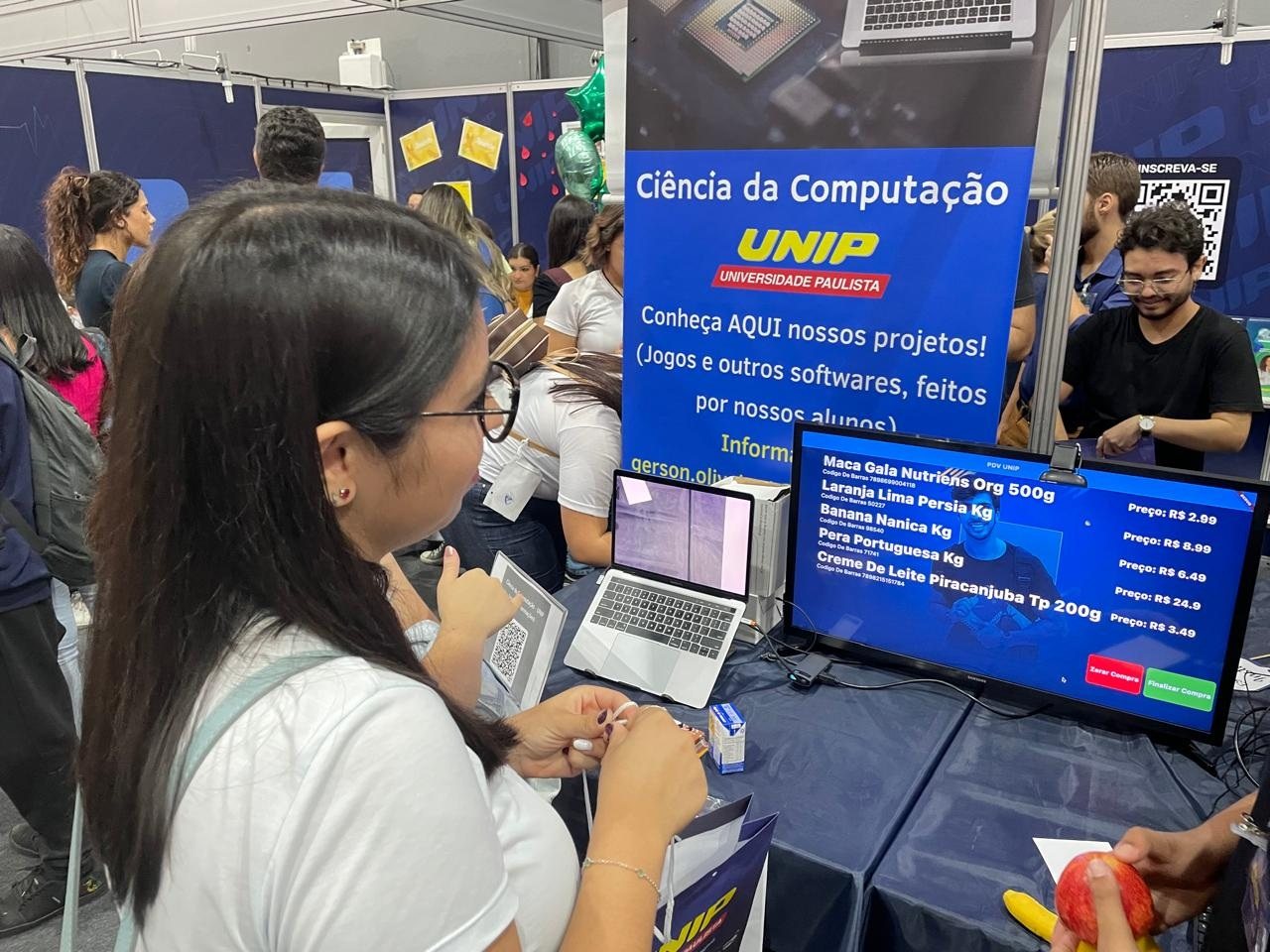 Estudante testa o sistema de ponto de venda no estande de Ciência da Computação
